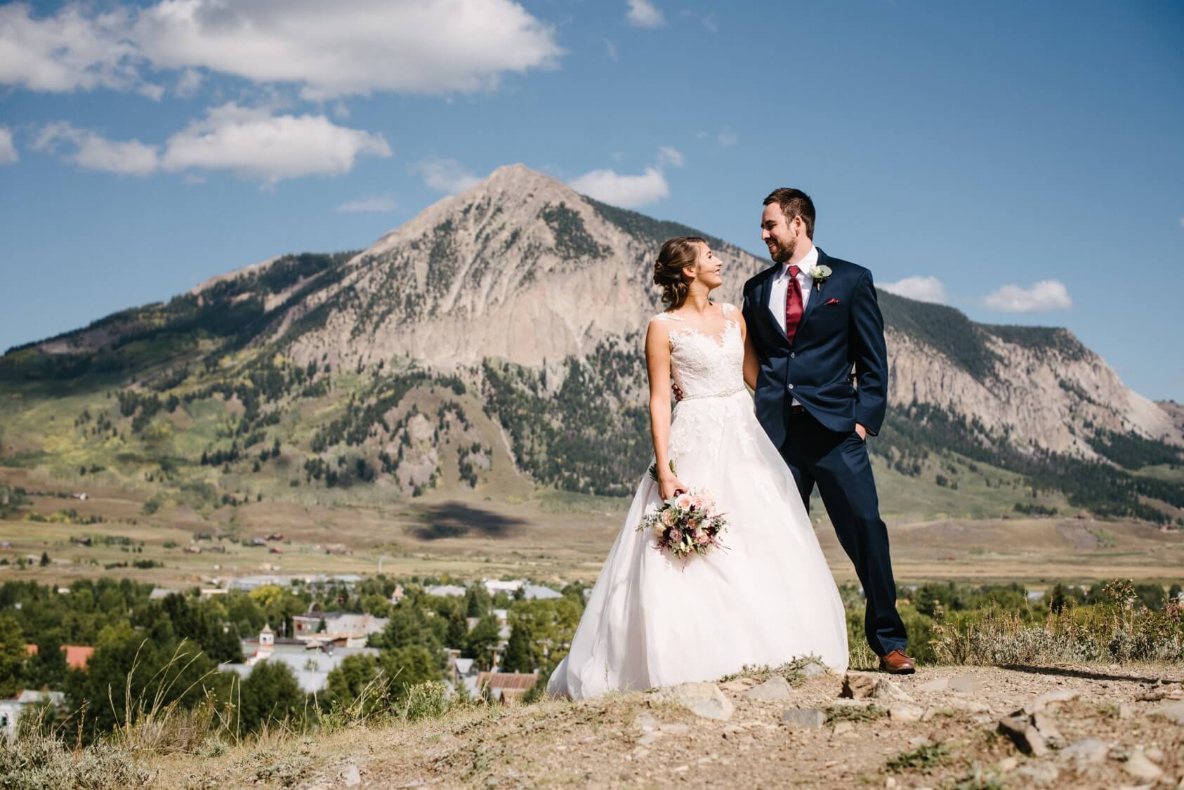 bride in a lace dress and groom wearing Michael Kors Navy Sterling Wedding Suit