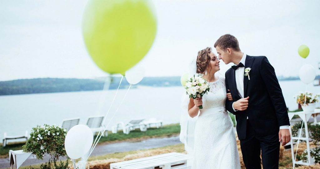 wedding couple walking on shoreline at reception