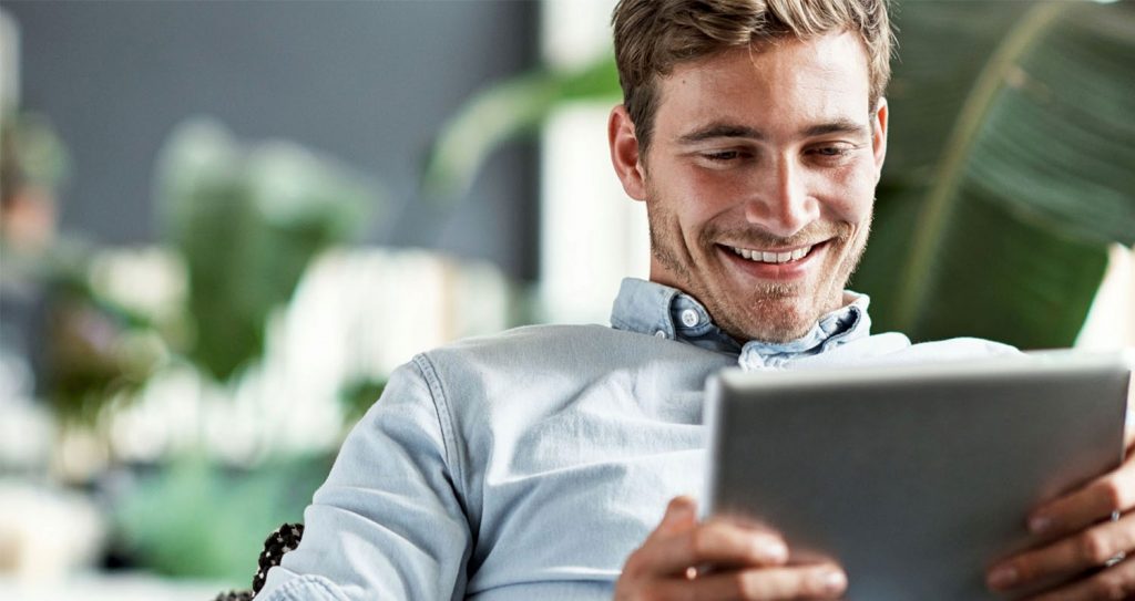 young man researching on computer at home