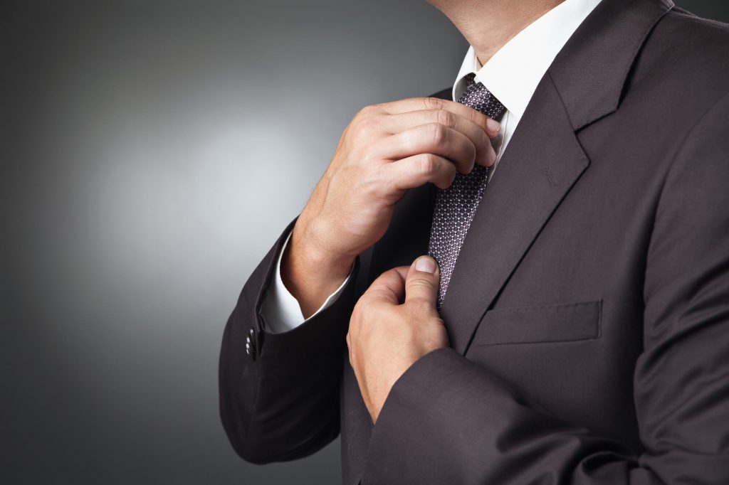 adjusting tie while showing off lapel