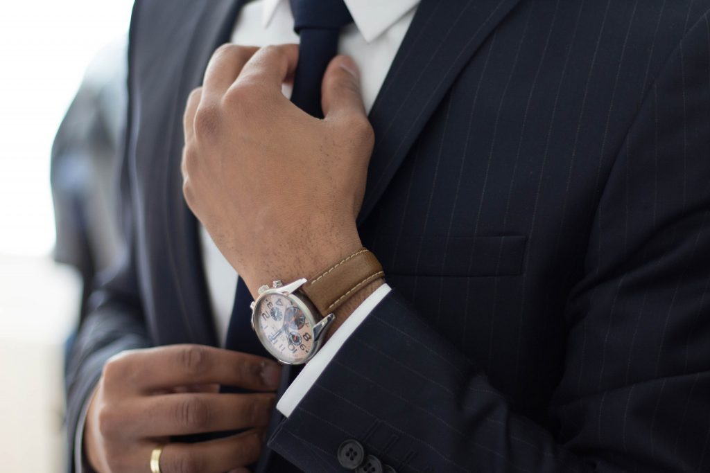 Buying your first suit - Man adjusting his tie - Jim's Formal Wear