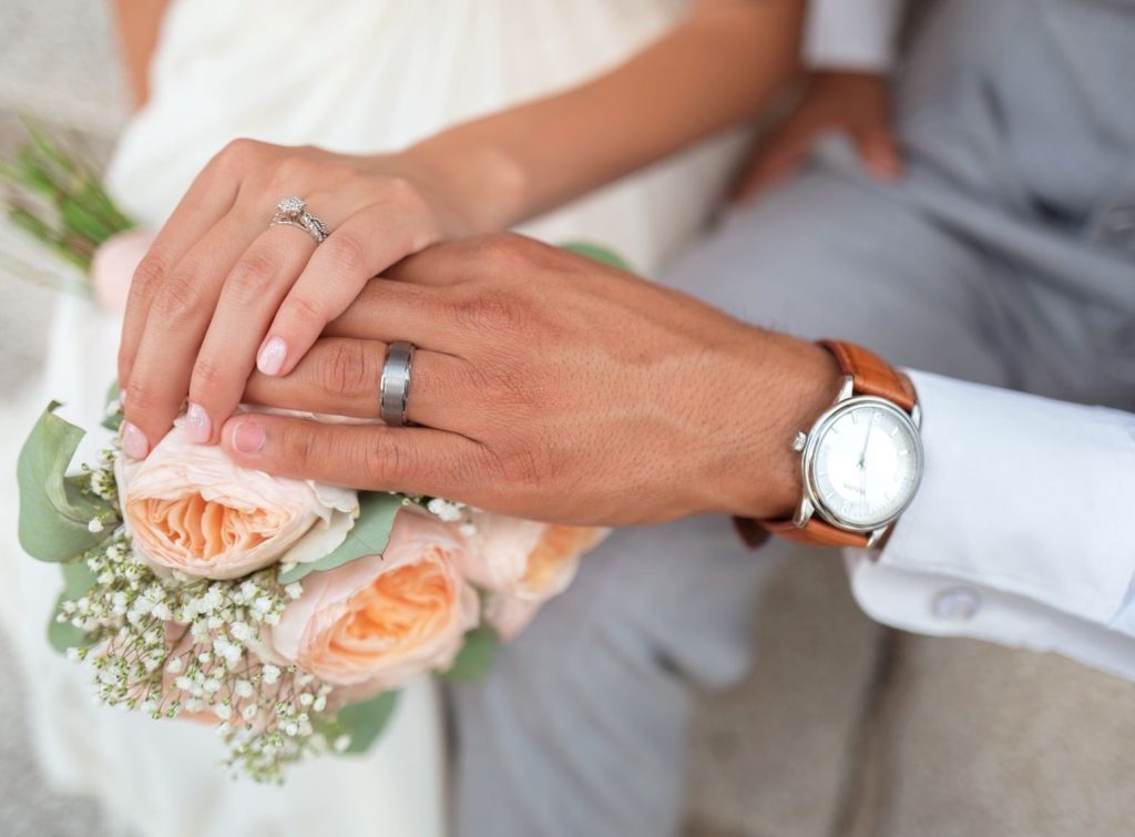 Ultimate Wedding Checklist for Grooms - Married Couple holding hands with wedding rings