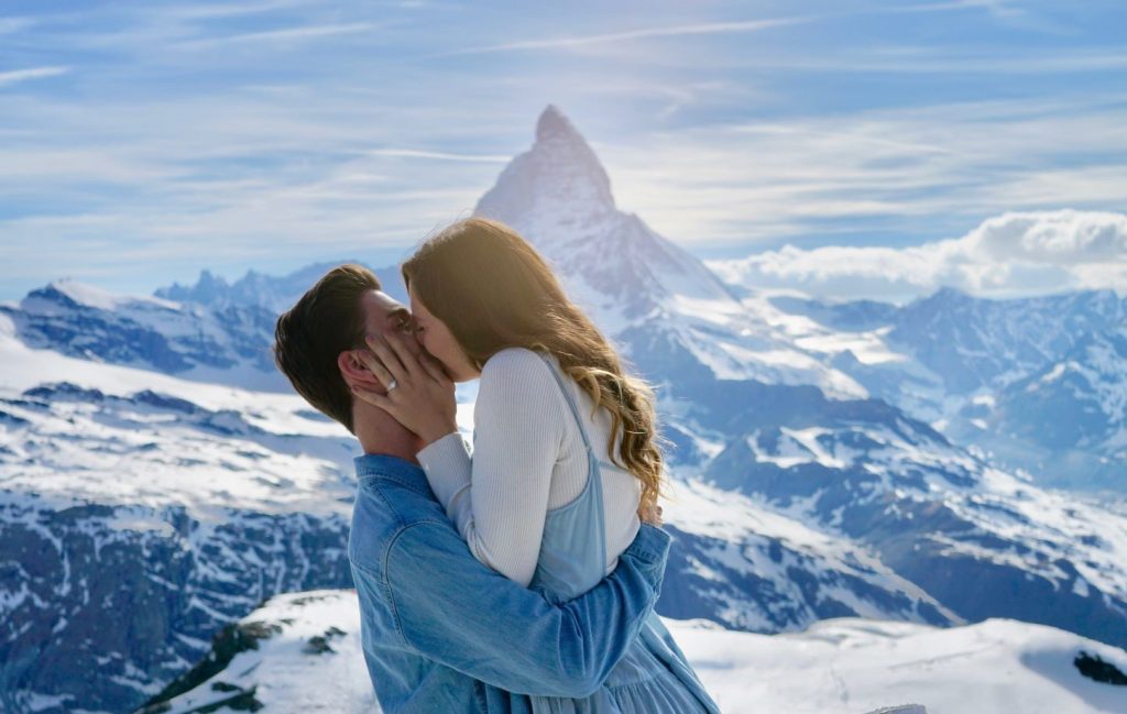 Creative Proposal Ideas - Man holding up women in front of a snowy mountain