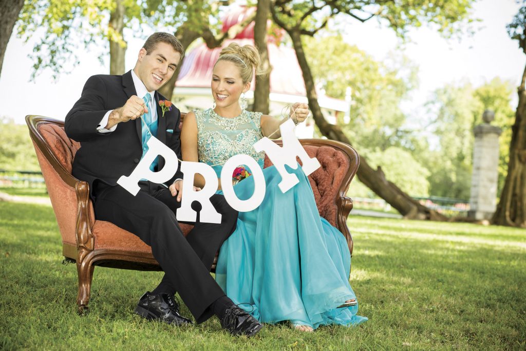 Best Promposal Ideas - Couple sitting on a bench with a prom sign