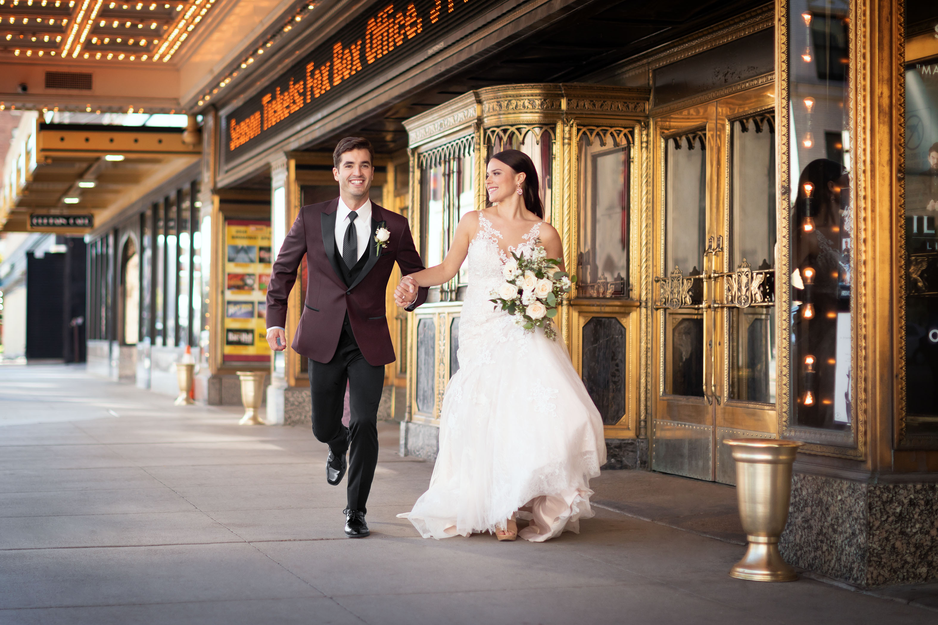 fall wedding colors -bride running with groom wearing burgundy jacket and black pants