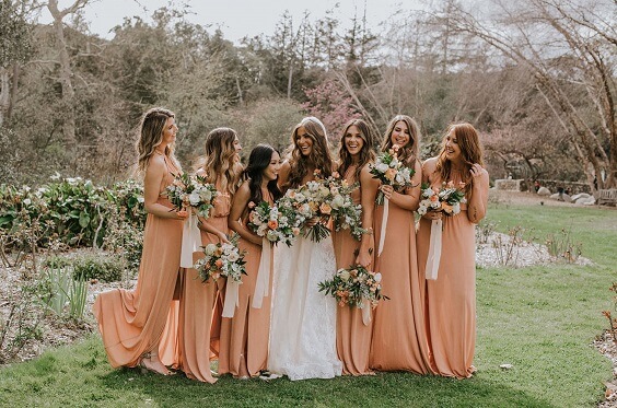 bride with bridesmaids wearing orange gowns