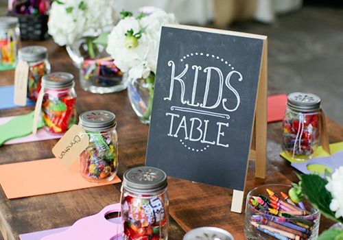 entertain kids at wedding - Kids table at wedding with chalkboard sign, crayons, candy