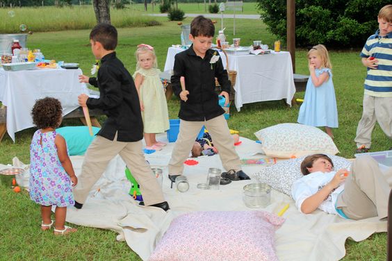 entertain kids at wedding - kids playing on blanket at outdoor wedding