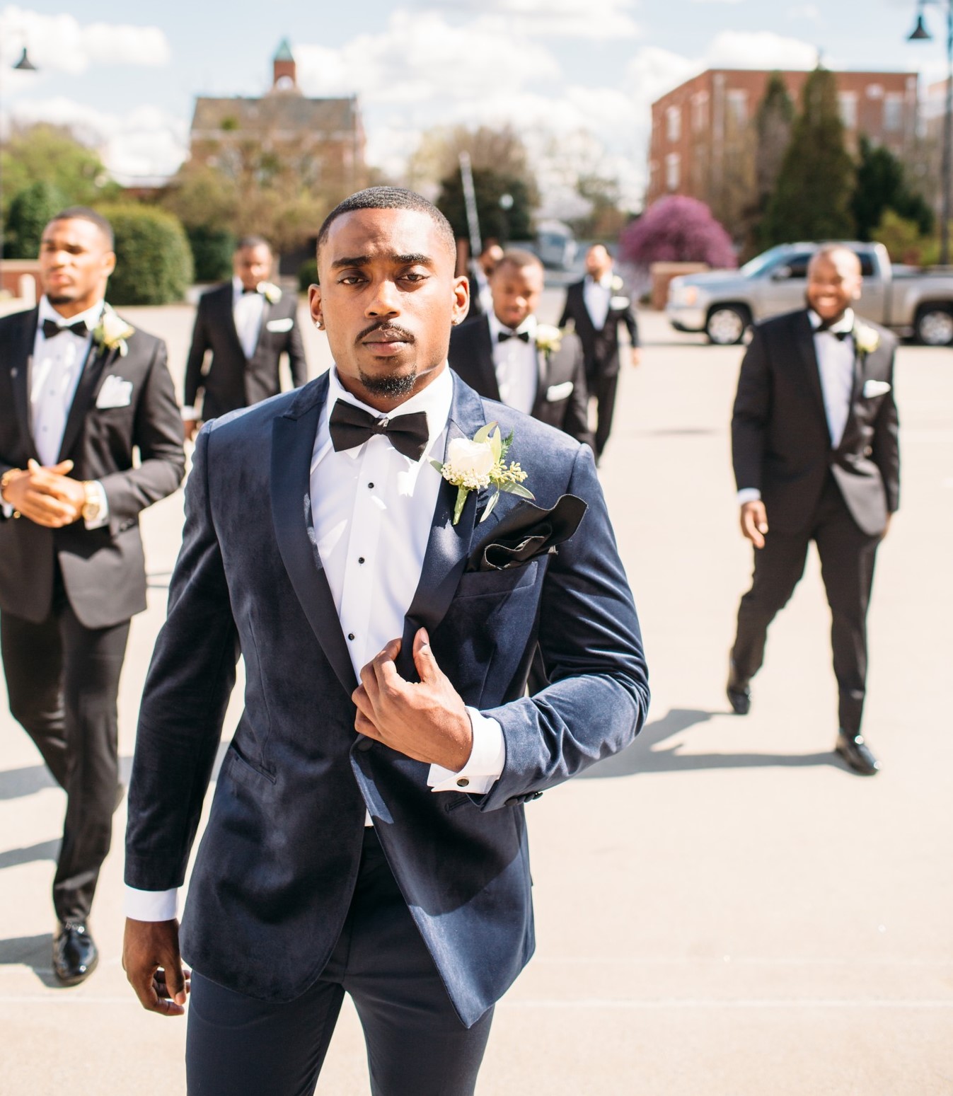 groom in slim fit navy velvet coat and groomsmen in black suits