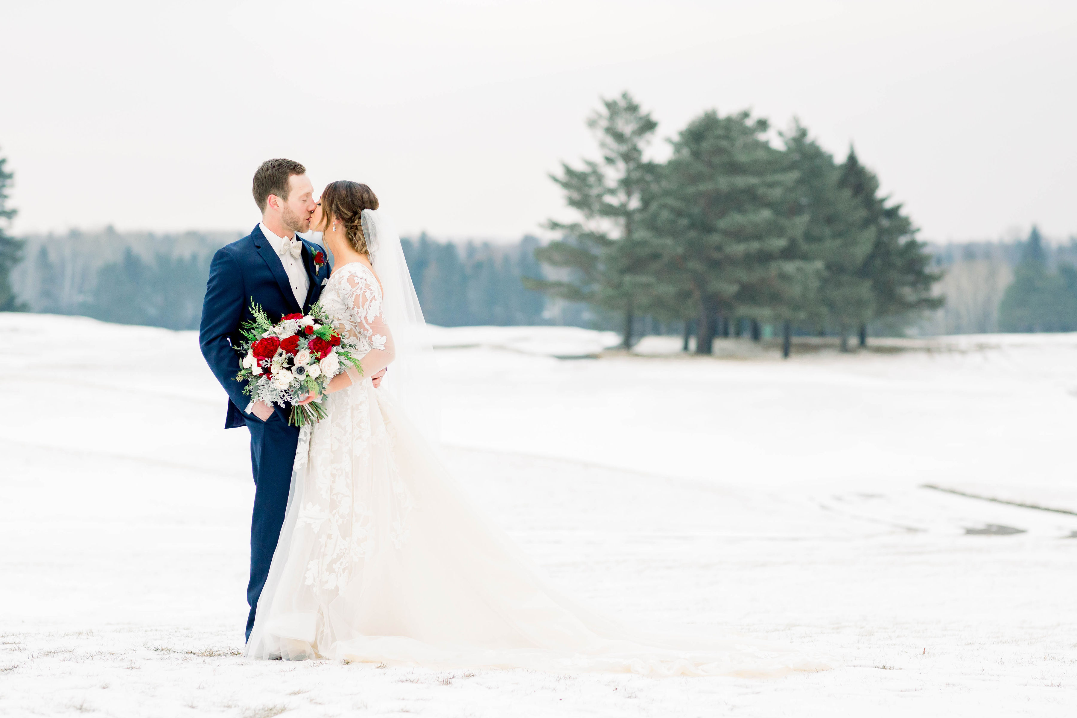 bride and groom kissing in snow