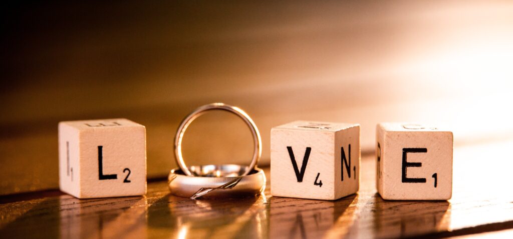 letter blocks spelling love with wedding rings - wedding insurance