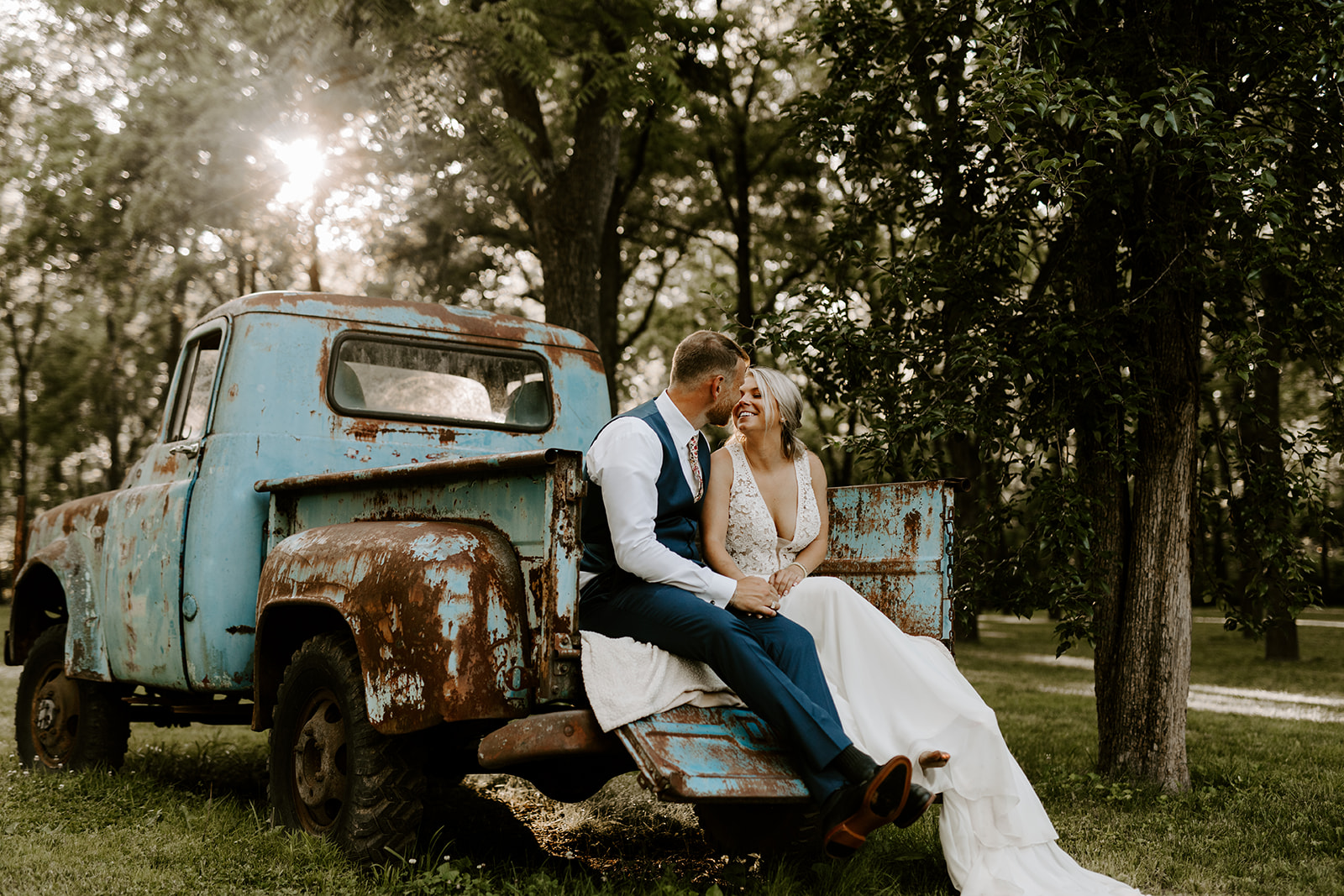 tasks to delegate - bride and groom sharing a moment on the back of an old truck