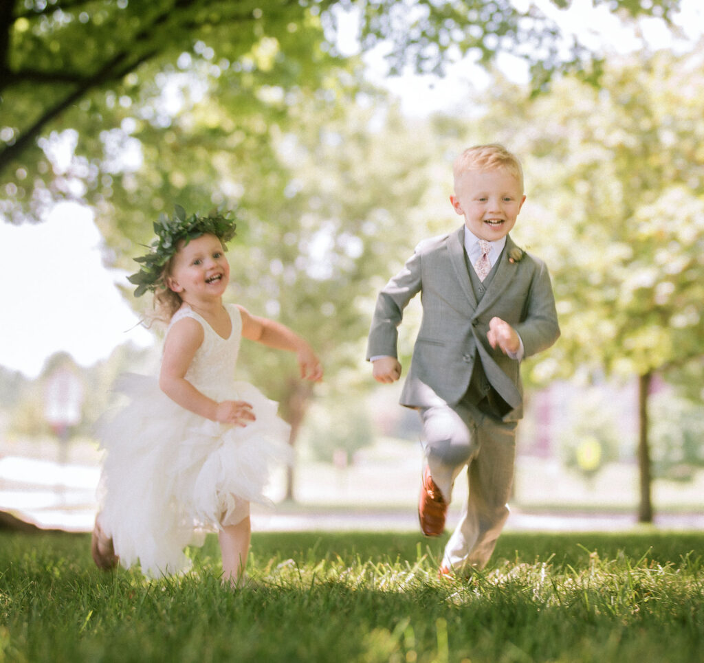 tasks to delegate on your wedding - ringbearer and flower girl running outside