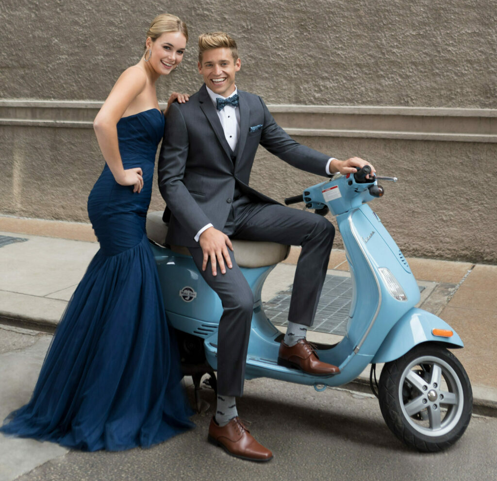 save money on prom with alternate transportation - prom guy in grey suit and prom girl in navy dress arrive on a Vespa scooter