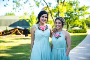 bridesmaids in mint gren dress and floral necklaces at a summer wedding