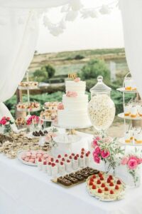 dessert table with popcorn, wedding cake, brownies, fruit, pudding, cake pops