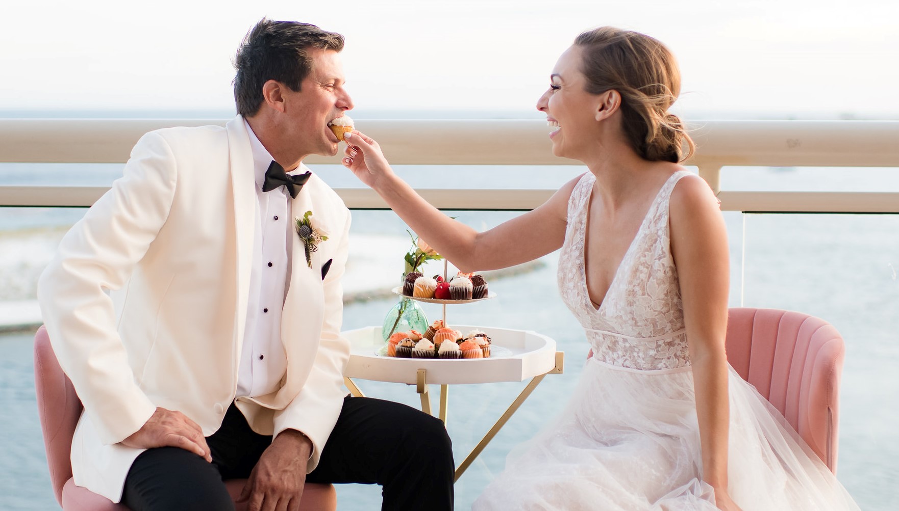 Bride feeding groom cupcake