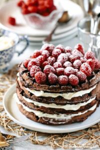 chocolate waffles stacked with cream layered inbetween with fresh raspberries