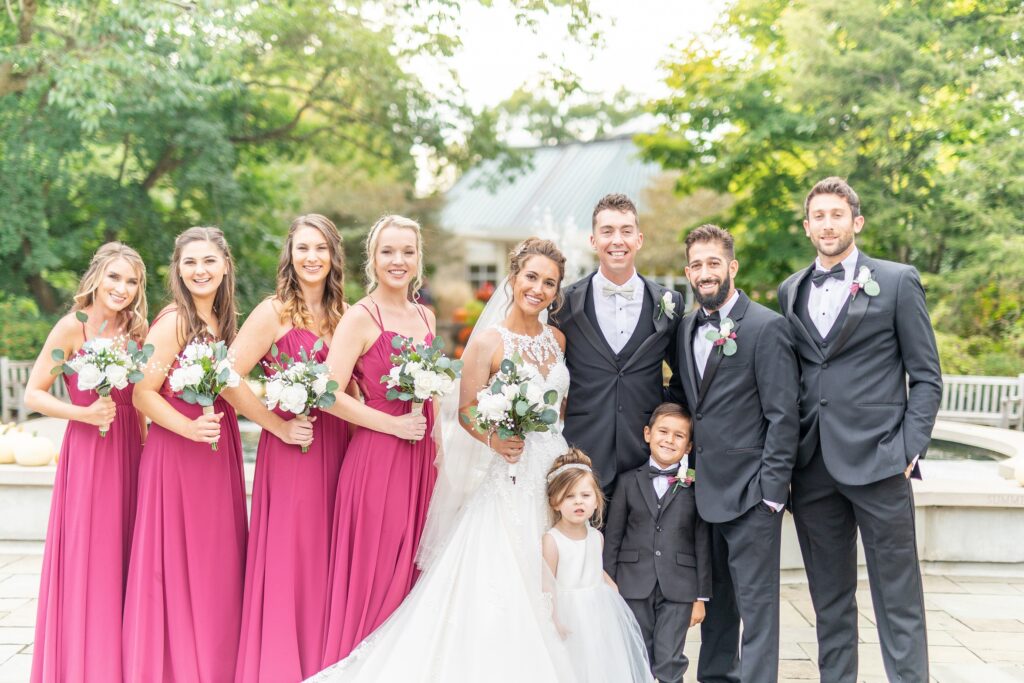 custom tuxedo - full wedding party with men in black tuxedos and women in bright pink dresses