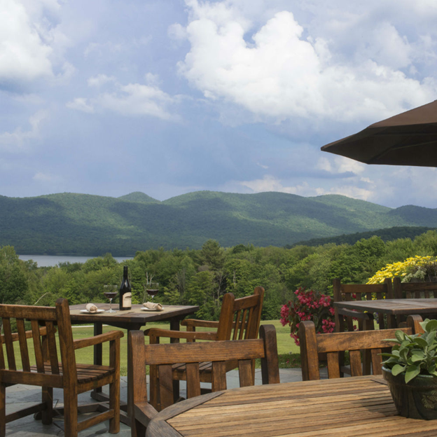 tables and chairs on a deck overlooking the mountain view