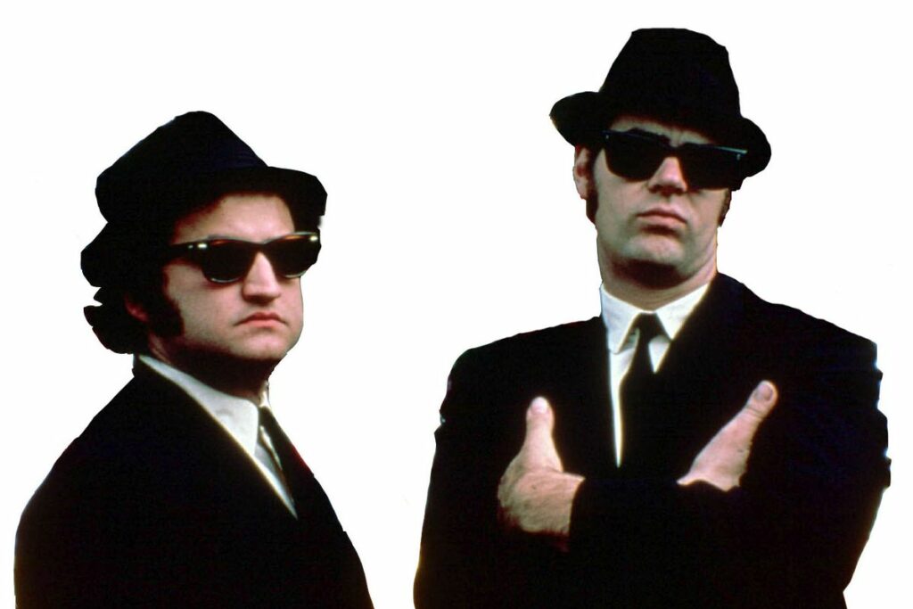 blues brothers in black suits, white shirts, black ties, and black fedoras