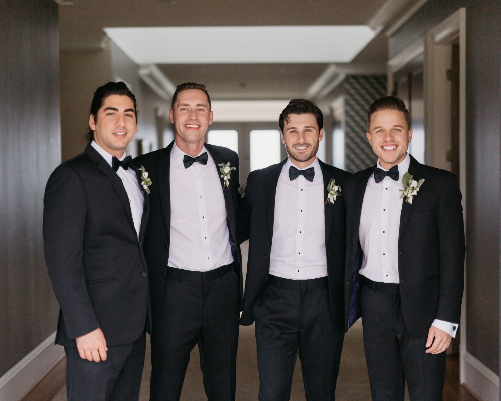 four white guys in black suits