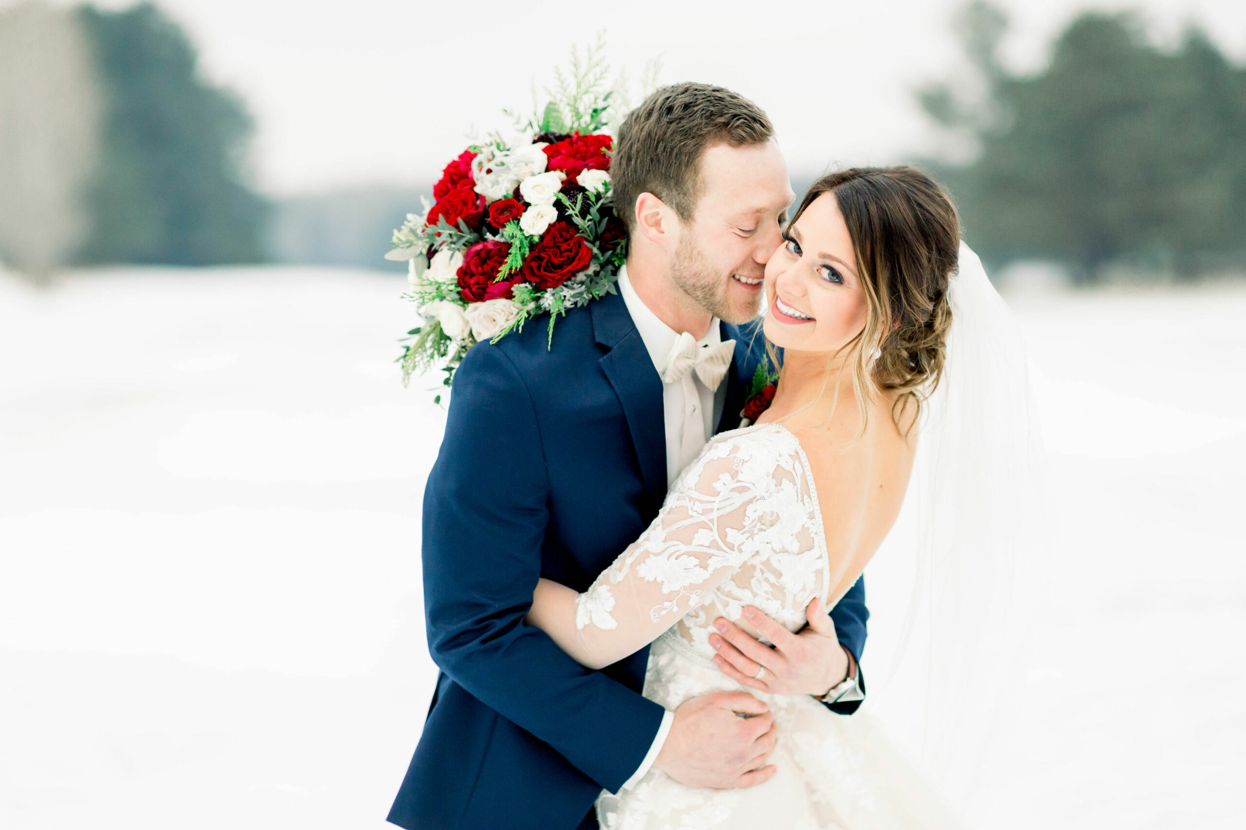 bride and groom hugging at winter wedding outside