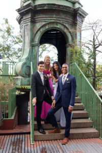 2 high school guys in prom tuxes and 2 high school girls in prom dress. All standing on stairs for group shot in front of structure 