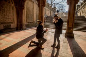 guy on one knee proposing to girlfriend near stairs