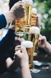 group of guys toasting with large mugs of draft beer