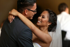 first dance for bride and groom, bride smiling and looking at groom with her arm wrapped around his neck