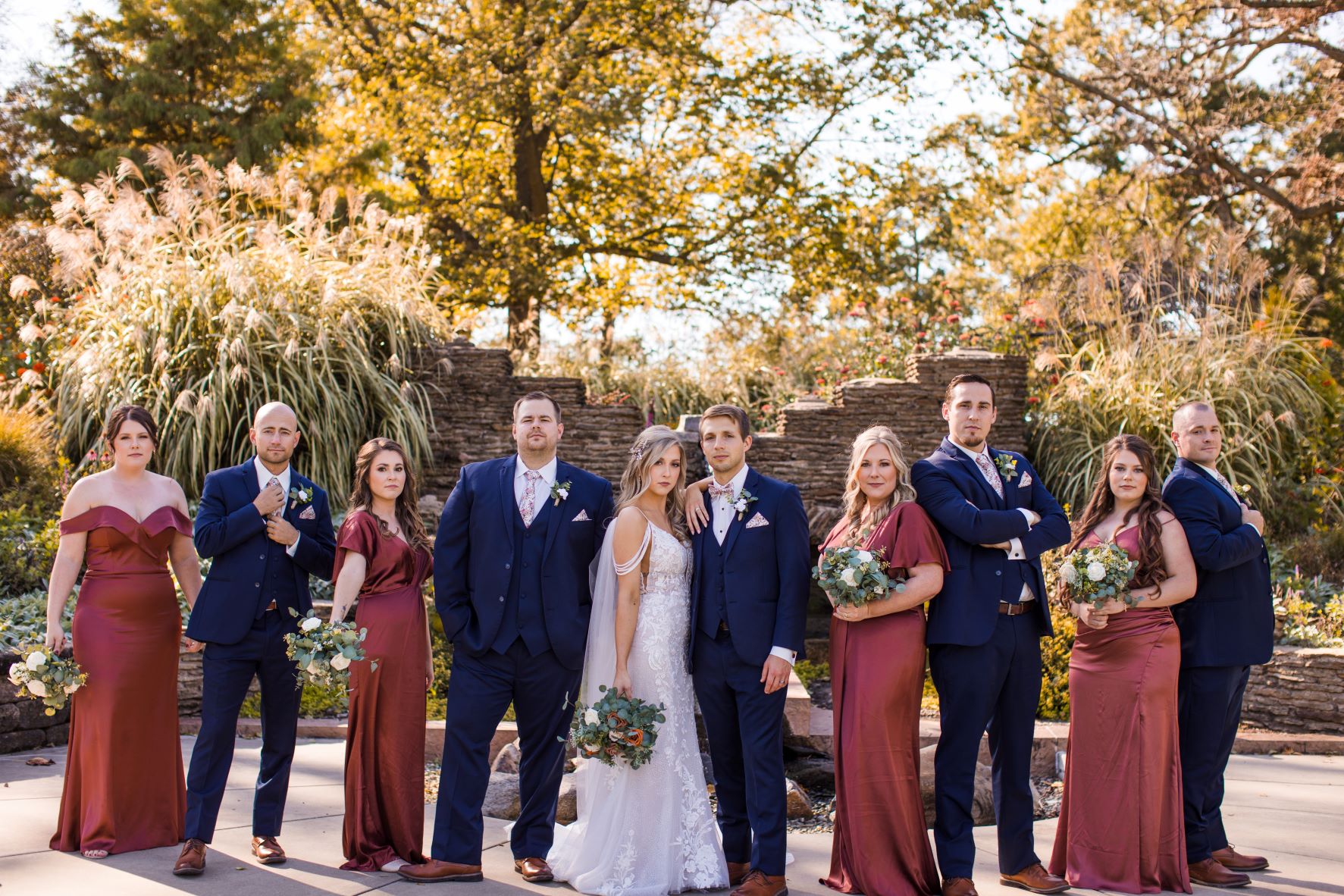 bridal party with guys in navy suits, bride in white wedding dress, bridesmaids in cinnamon colored dresses