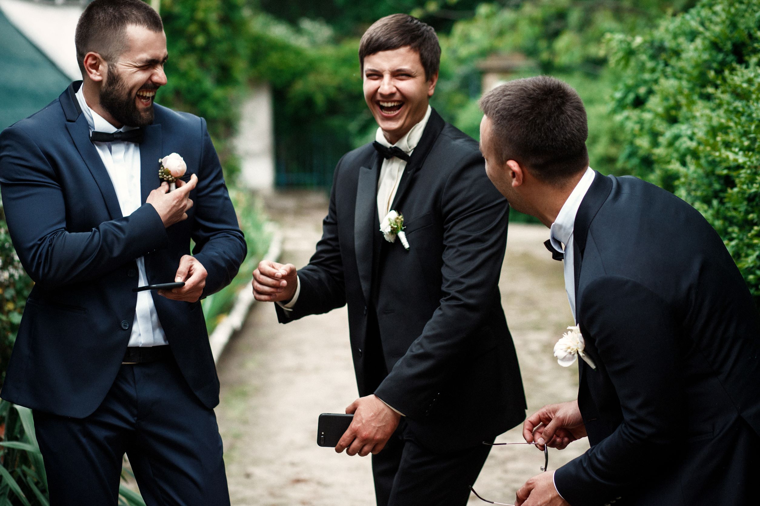 grooms and his best mans in tuxedos, laughing