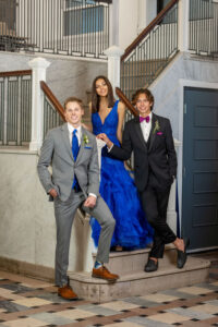high school boy in grey suit with royal blue accessories, girl in royal blue dress, other boy in black tux with Persian plum accessories. 