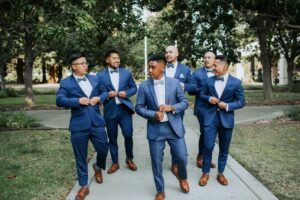 groom and groomsmen walking, wearing blue wedding suit and tuxedo