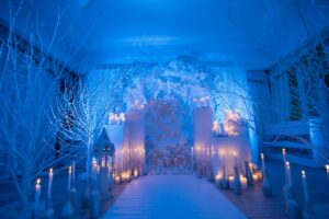 winter wedding aisle with white bare trees and candles lining aisle 