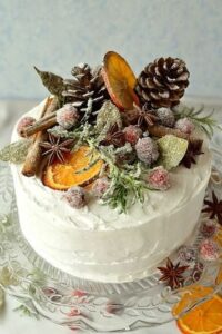 wedding cake with dried fruit, cinnamon sticks, and pinecones on top.