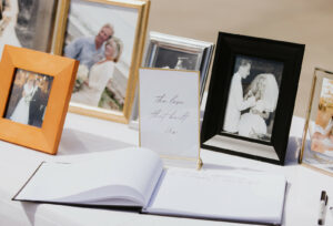 guest book at wedding with pictures of family members in the background