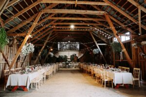 wedding venue in a barn with exposed beams, and tables for the reception