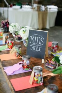 a kid's table to entertain kids at the wedding. Table had jards of candies and crayons to color 