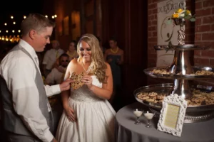bride and groom sharing a cookie at their wedding