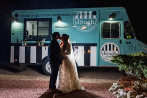 bride and groom kissing in front of edible cook dough food truck