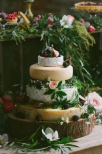 variety of cheese wheels stacked like a wedding cake