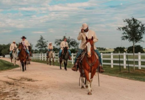 groomsmen riding horses to the wedding