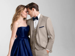 prom trends - guy in sand brunswick suit and navy accessories next to girl in navy strapless dress.