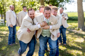 groomsmen rushing the groom for a big hug