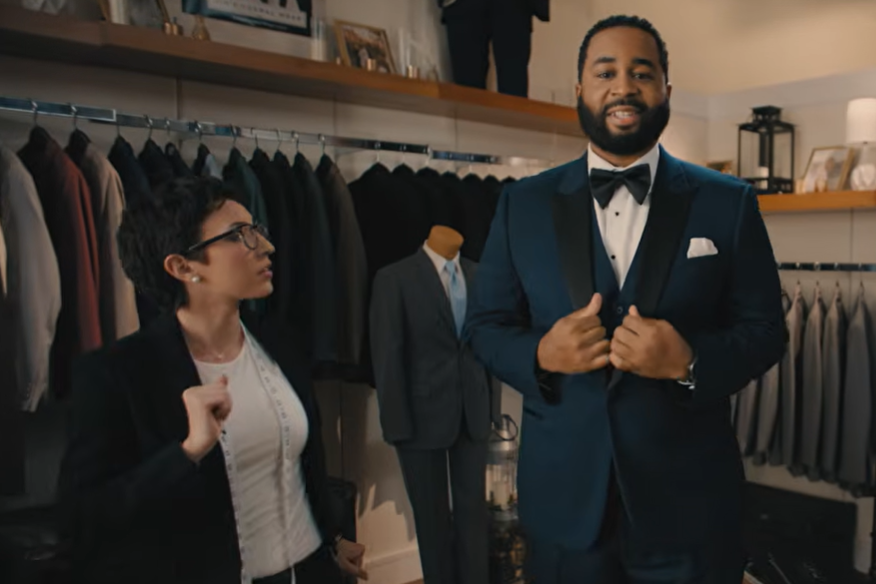 Groom at a local Jim's Formal Wear retailer trying on a navy tuxedo